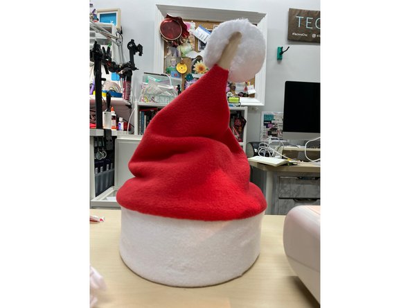 Tuck the Santa hat into the outer ring. Insert the hat structure inside.