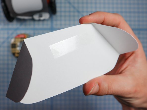 Add double-sided tape or a dot of glue to the center of the inside of the wings.