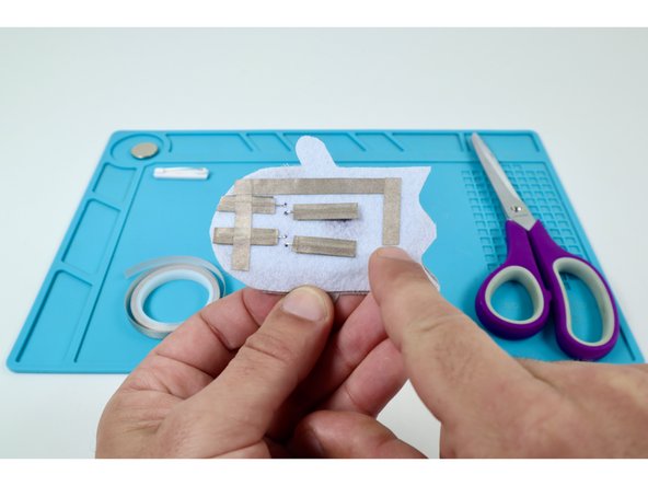 The second path should overlap the first and go down the right side of the felt embellishment. Make sure it does not contact the remaining (long) LED legs.