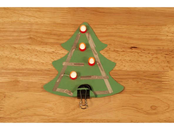 If you use a binder clip it should still be able to fit over two batteries.