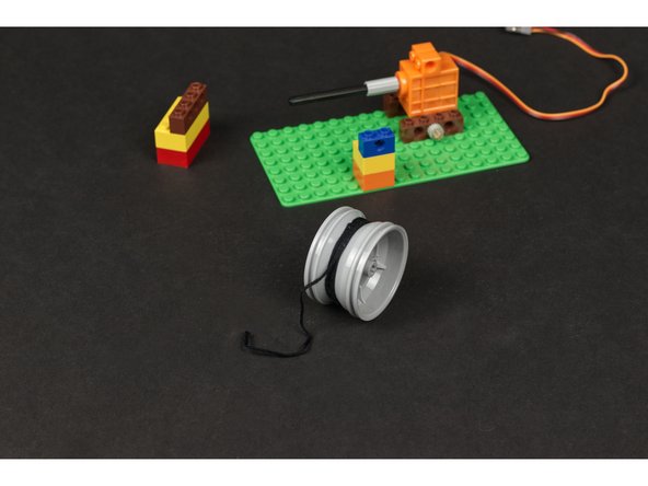 Tie the string tight onto the wheel/rim and wind it around a few times.