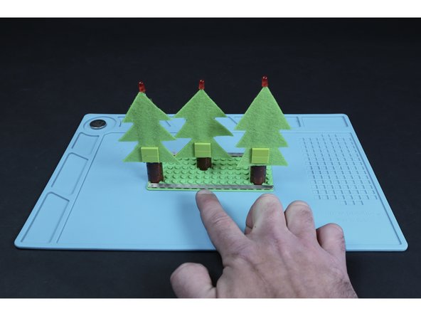Turn your project around. Measure, cut, peel and stick another long path atop the single row of posts in front of the trees. This path should reach from edge-to-edge like the first long path.