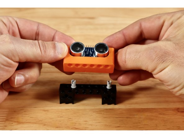 Press two connector pins into place in the holes of the (1x8) brick as shown. There should be 4 empty holes left between these pins on the (1x8) brick.