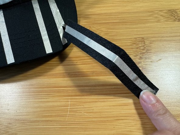 The fourth piece of Maker Tape is touching the positive side of the battery. Cut a strip of felt and stick a piece of Maker Tape to it as shown, then attach that piece to the positive piece.