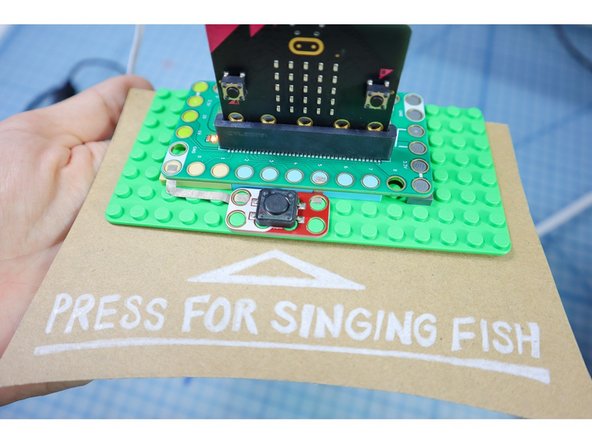 Add a button to Pin 5 with Maker Tape as shown. (Pin 5 is also connected with Button A on the micro:bit, so it works with the &quot;Button A Pressed&quot; block.)