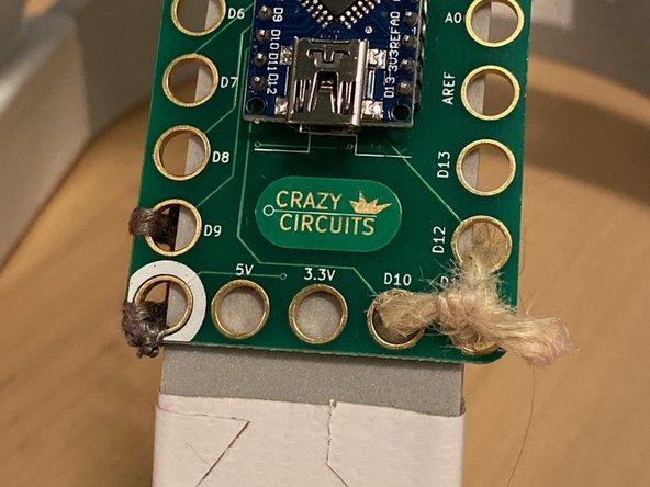 Tip: Use a small piece of tape to hold the button in place while you sew. Trim any stray threads and use nail polish to set the thread once you've checked that it works.