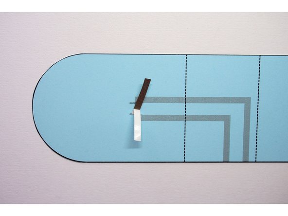 Peel off the backing, but only for the piece of Maker Tape sticking out on the inside