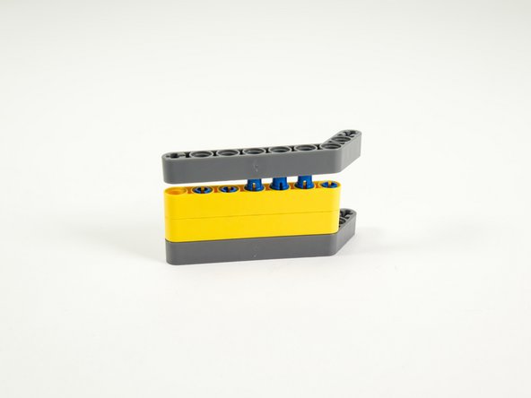 Finally, add the top gray angled beam, pressing it onto the pins so it fits tight against the beam below it.