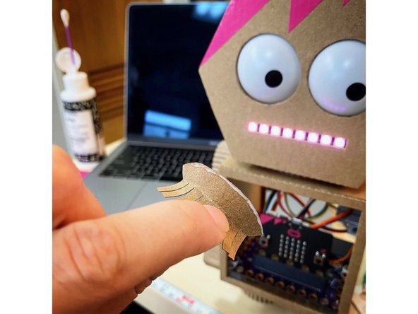 We made her some eyelashes out of the paper that was torn off of the cardboard. We glued them on using white glue, but the process felt a lot like gluing on real false eyelashes!