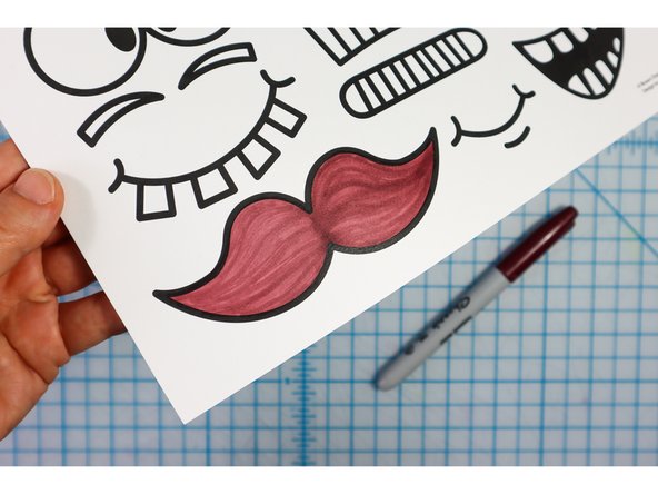 Choose funny face features from the template and color in the ones you pick, then cut them out.