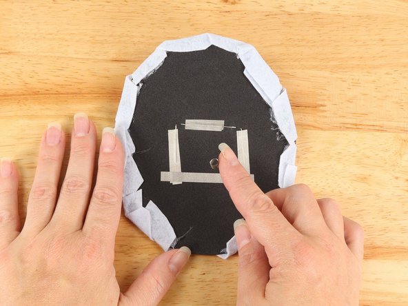 Make a loop of tape (sticky side out) using a short piece of Maker Tape, and stick it atop the middle of the tape pathway connecting the two longer (Negative) pathways.