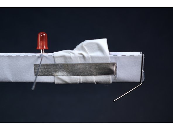 With the battery secured and held in contact with the inside Maker Tape pathways by your Gaff/Duct tape wraps, peel/cut the backing from that last section of Maker Tape and stick it down over the wraps you just finished.