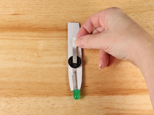Add Maker Tape to connect the top (Positive) side of the battery to the handle.