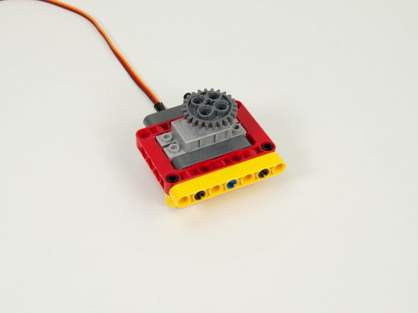 Attach the large gray gear to the servo by pressing it into place.