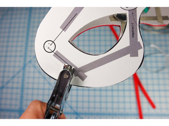 If you plan to add a ribbon to tie the mask to the wearer's face, punch the hole where shown.