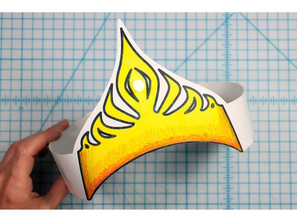 Cut out the side strips and tape them to the hat with the slits facing up on one side and down on the other. 