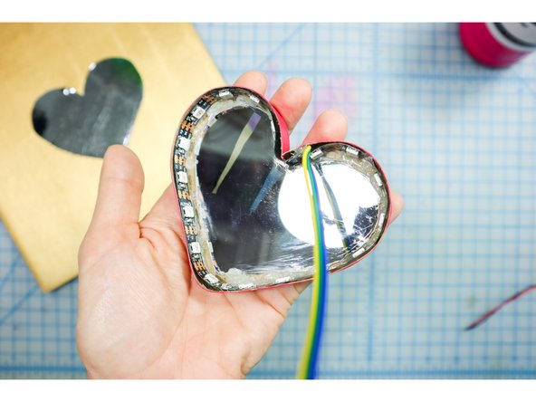 Glue the two-way mirror piece inside the heart box. Remove the protective coating, and be careful not to scratch it.