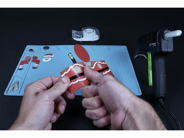 Using a pencil as shown, pull your chosen project against this round shape from straight edge to straight edge. This will give the project a curl and make it easier to turn into a tube when necessary.