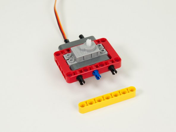 Add a yellow 7 beam to the pins on the front of the assembly.