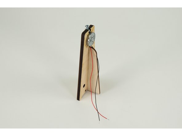 It just slots together loosely, but the entire assembly will be held down to the base using twisted wire, just the like side walls of the house.