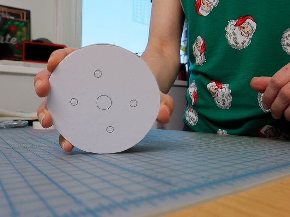 Use a hole punch to punch out each of the outer holes, and an awl to put a hole thru the inner holes.