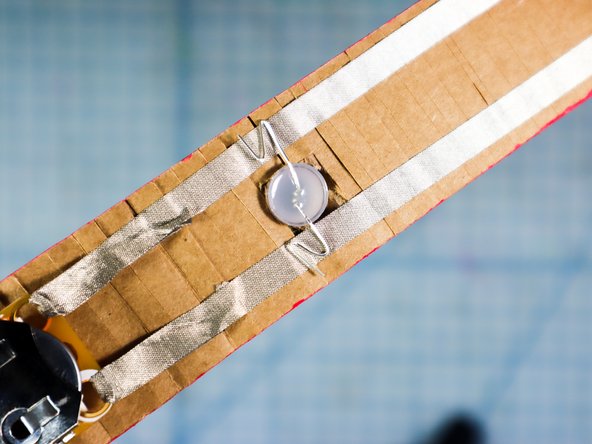 Tuck the LED legs into the belt by folding them back and forth as shown. We've found that this makes a more reliable connection to Maker Tape than cutting the legs.