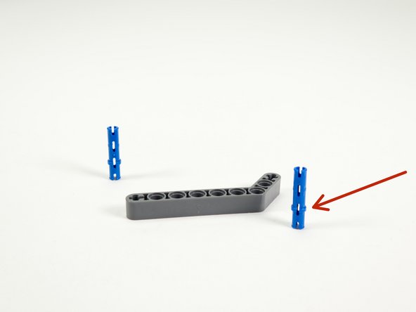 Insert two long blue pins into the gray angled beam as shown.