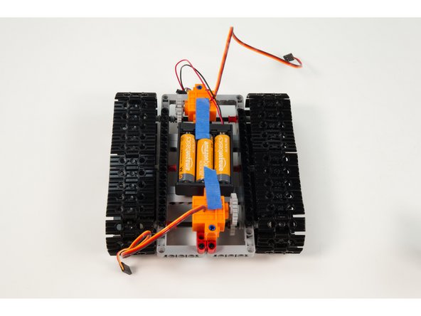 We chose a very simple method of adding the 3 AA Battery Pack. It sits below the Robotics Board and we just taped it to the servos to keep from moving around too much. (The &quot;legs&quot; we added to our Robotics Board will also help keep it in place.)