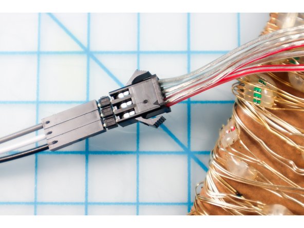 Plug the jumper wires into the NeoPixel string using three long headers as shown.