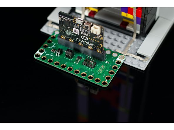 We're going to place our Bit Board onto the back of the baseplate, behind HAL, so we can run the Maker Tape to Pins 5, 8, and Ground for the button and LED.