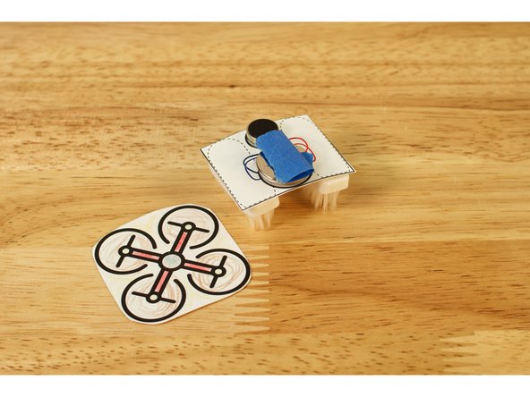 Just make a tape loop with some blue painter's tape and stick the body on top of the battery.