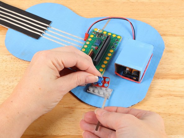 Use a piece of Maker Tape to start a path from the bottom hole of the potentiometer as pictured. 