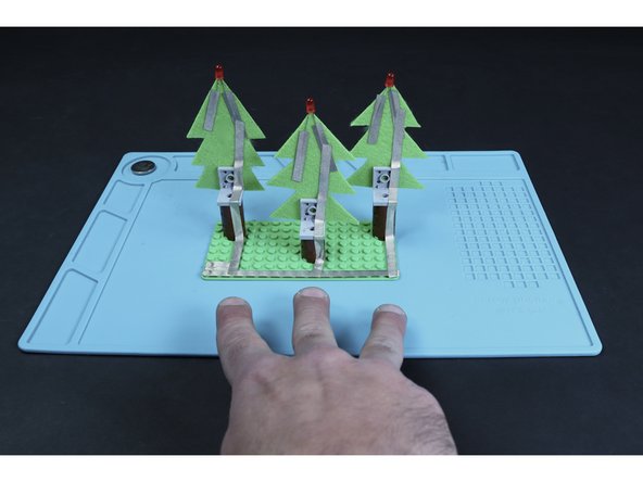 Create a single path that connects to the tape from each of the 3 short LED legs (they should be on the right hand side of each tree when viewed from the back), down the right half of each tree/trunk and to the long path you first laid down.