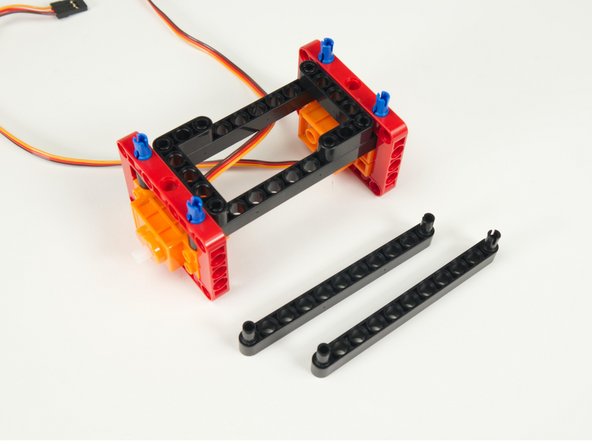 Add two black pins to each black beam and attach them as shown.