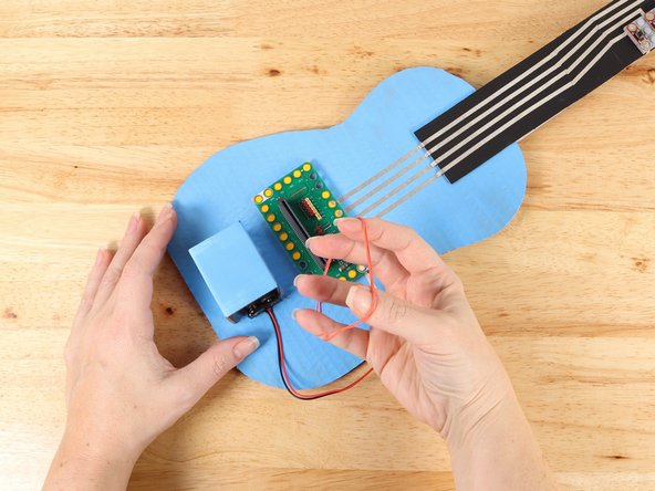 Slide the Battery Pack into the compartment and secure it in place with a rubber band.