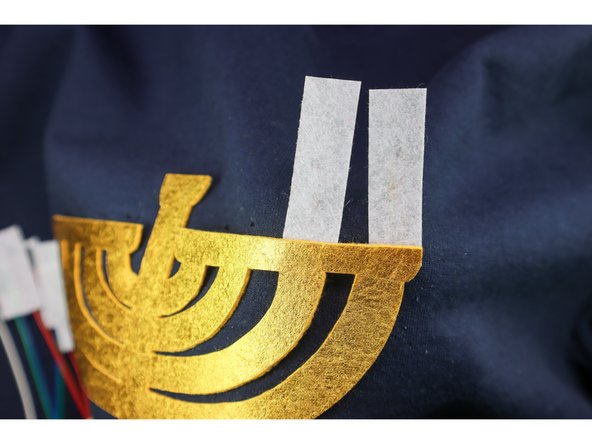 Thread the wires through each pair of holes, making sure that the candle faces front when the wires are pulled all the way through.