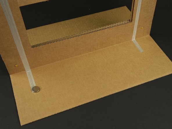 We'll start by making a small loop of tape, then sticking the battery down to it (positive side facing up).