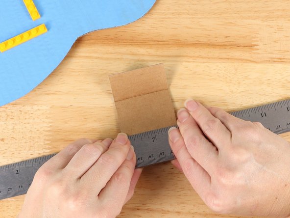 Using a straight edge like a ruler, fold the battery compartment along the lines to form a u-shape.