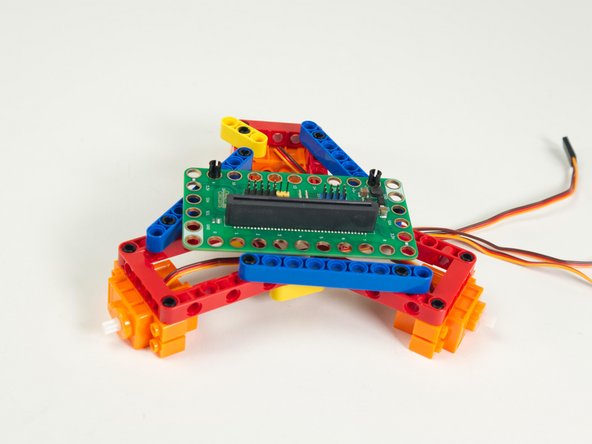 Add a servo to each red frame as shown.