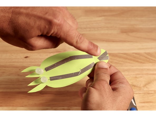 After bringing the tape pathways from the back side to the front, they should end where shown to create a small gap between them and the two paths on the front.