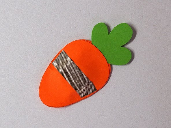 Add a strip of Maker Tape to one side of the carrot, making sure that it's on top of the magnet (since that's where it'll stick best to the Rabbot)