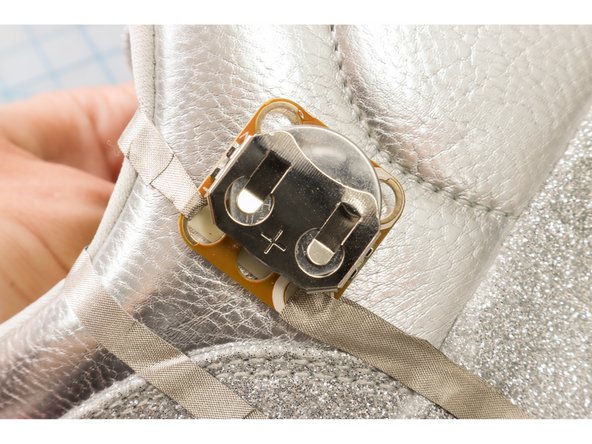 Use a piece of double-sided mounting tape to attach the Crazy Circuits battery holder to the shoe. Insert the Battery.