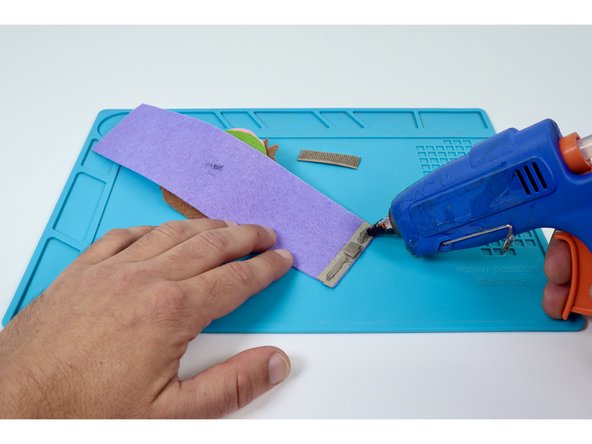 Use a hot glue gun to put a small bead of glue atop the edge pad on each side of the tape loop. Do not put glue on the tape loop.