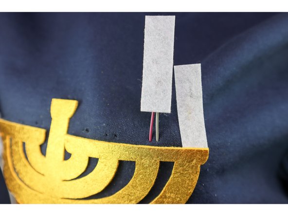 Thread the wires through each pair of holes, making sure that the candle faces front when the wires are pulled all the way through.