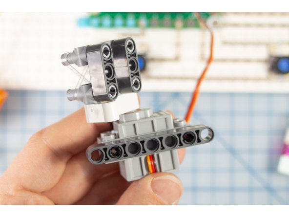 Add two pins to connect the beam piece to the side of the motor that has the pen holder.