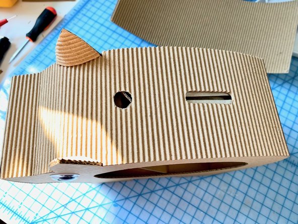 For the front of the nose, we cut out two ovals for the nostrils. Before gluing it in place, we painted another piece of cardboard black and glued it behind the holes. We did this because it would have been harder to paint the interior of the nostrils later. :)