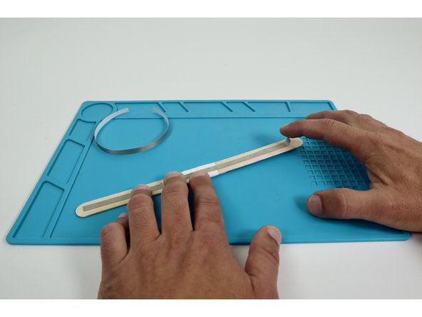 Place each of the two long Maker Tape pieces so they run end-to-end down the middle of each side of the wand handle.