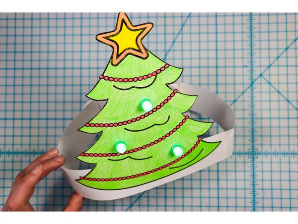 Cut out the side strips and tape them to the hat with the slits facing up on one side and down on the other.