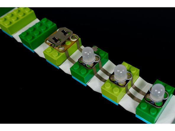 Using the circuit diagram as reference, press the Crazy Circuits components into place atop the bricks as shown.