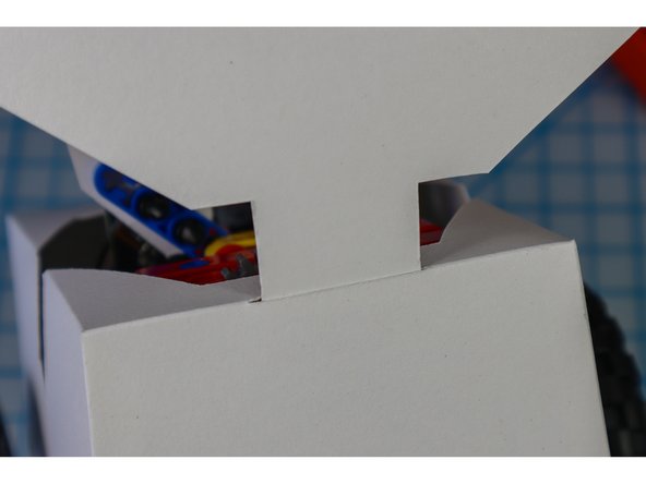 Insert the back head tab through the slit in the back fo the body.